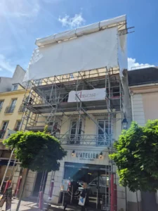 Immeuble en rénovation à St Germain en Laye avec un échafaudage au dessus de la crêperie l'Atelier. Un chantier réalisé par Applitech Enveloppe