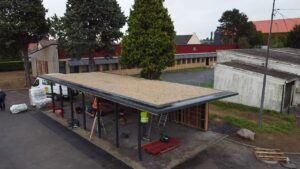 Préau de l’école Paul Sion à Courcelles-lez-Lens avec structure métallique et toiture en finition, en cours de réalisation par Applitech Enveloppe.