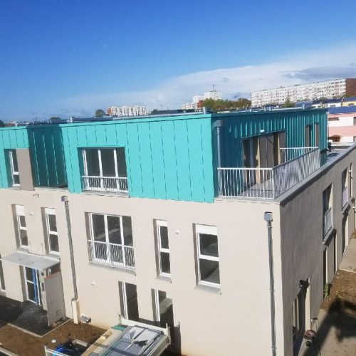 Vue d’ensemble de logements collectifs à Amiens avec façades enduites et bardage métallique en partie haute, travaux d’enveloppe du bâtiment réalisés par Applitech Enveloppe.