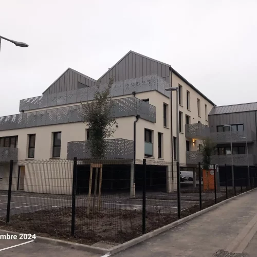 Immeuble de logements neufs à Marcq‑en‑Baroeul avec toiture et bardage métalliques et balcons en garde‑corps perforés, chantier d’étanchéité réalisé par Applitech Enveloppe