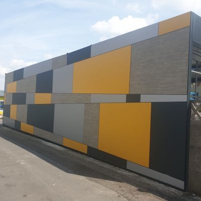 Vue extérieure du nouveau préau de l’école Fassiaux à Éleu-dit-Leauwette, habillé de panneaux de façade colorés, réalisé par Applitech Enveloppe.