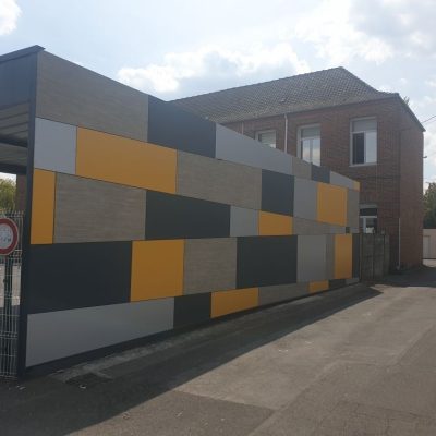 Bardage architectural en panneaux composites gris et jaunes sur le préau de l’école Fassiaux à Éleu-dit-Leauwette, réalisé par Applitech Enveloppe.