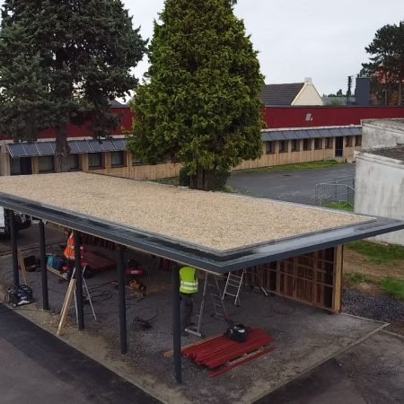 Préau de l’école Paul Sion à Courcelles-lez-Lens avec structure métallique et toiture en finition, en cours de réalisation par Applitech Enveloppe.