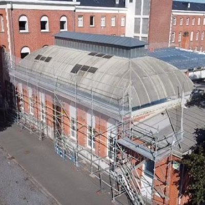 Bâtiment ancien en briques avec verrière et échafaudages lors d’une opération de réhabilitation de toiture à Lille, menée par Applitech Enveloppe.