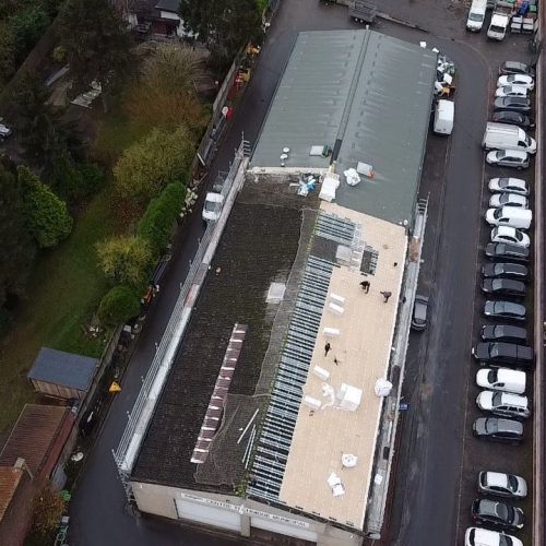 Applitech Enveloppe réhabilite la toiture du Centre Technique Municipal de Wattignies, vue aérienne du chantier en cours avec ancienne couverture, nouvelle isolation et ouvriers en intervention.