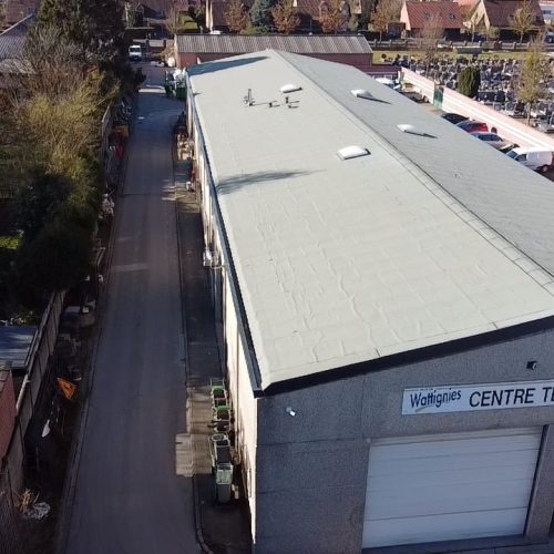 Applitech Enveloppe réhabilite la toiture du Centre Technique Municipal de Wattignies, vue verticale de la couverture complète avec lanterneaux, cheminées et stationnement alentour