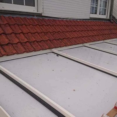 Toiture de véranda et couverture existante avant réfection de la toiture métallique, réhausse de charpente et remplacement de la véranda à Sainghin-en-Weppes, chantier Applitech Enveloppe.