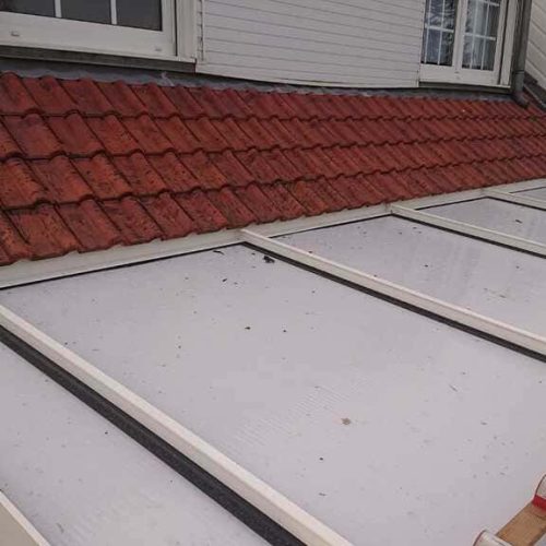 Toiture de véranda et couverture existante avant réfection de la toiture métallique, réhausse de charpente et remplacement de la véranda à Sainghin-en-Weppes, chantier Applitech Enveloppe.