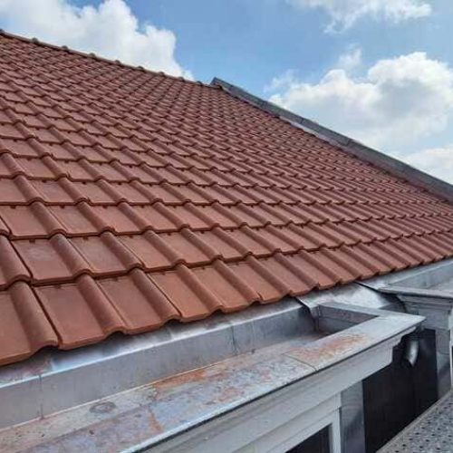 Toiture à réfection à Lille, mélange tuiles canal rouge usées et ardoises plates, en cours de chantier avec échafaudage par Applitech Enveloppe.